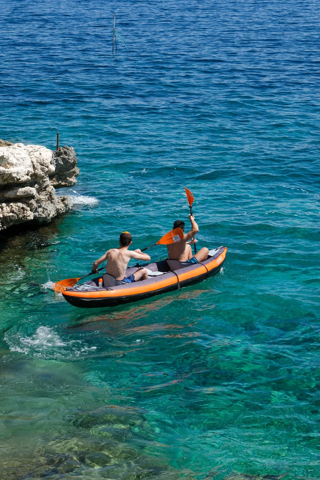 Deux personnes en kayak le long d’une côte rocheuse — photo d’illustration