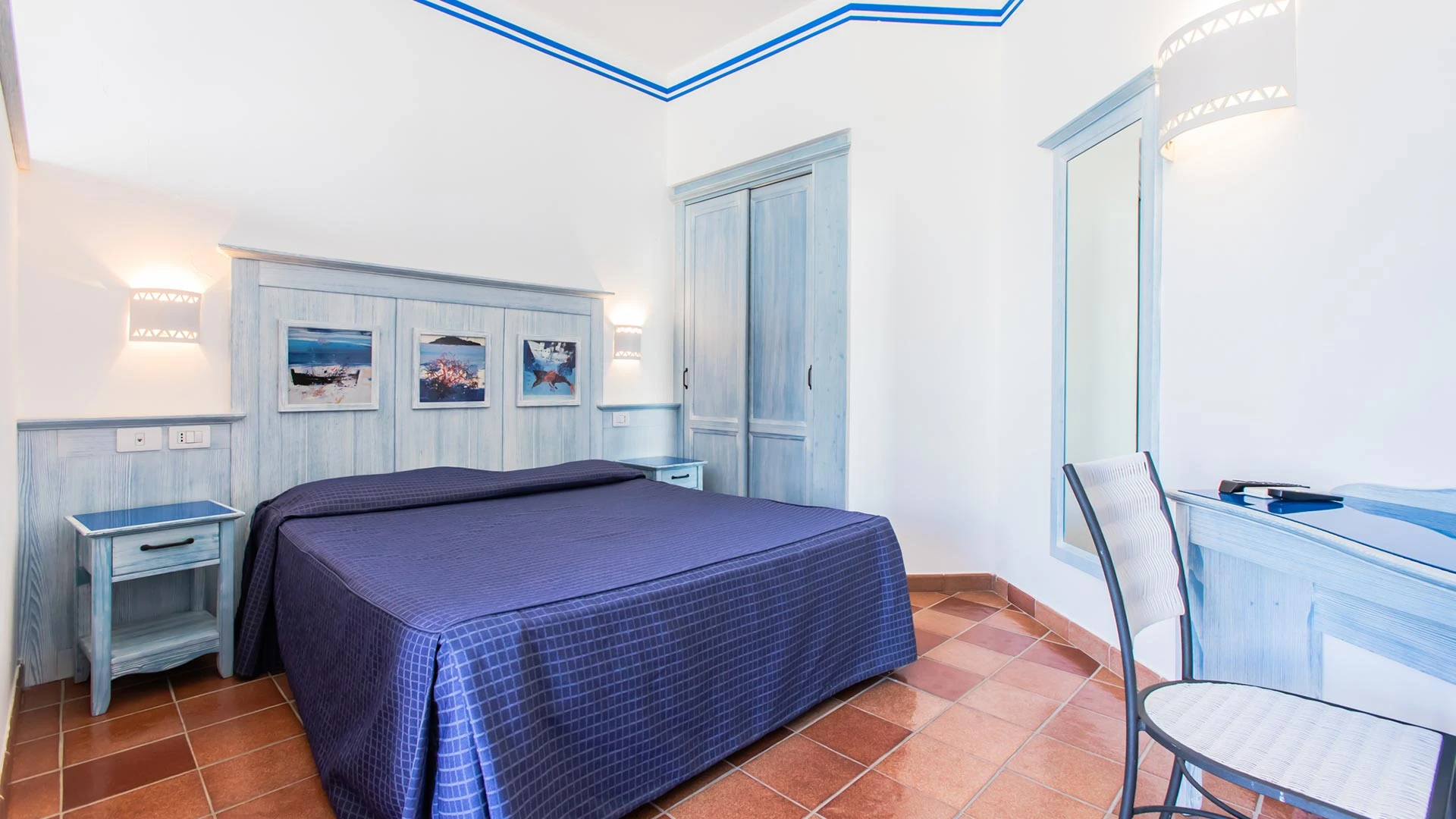 Camera Cala La Luna con letto matrimoniale, arredi azzurri e pavimento in cotto