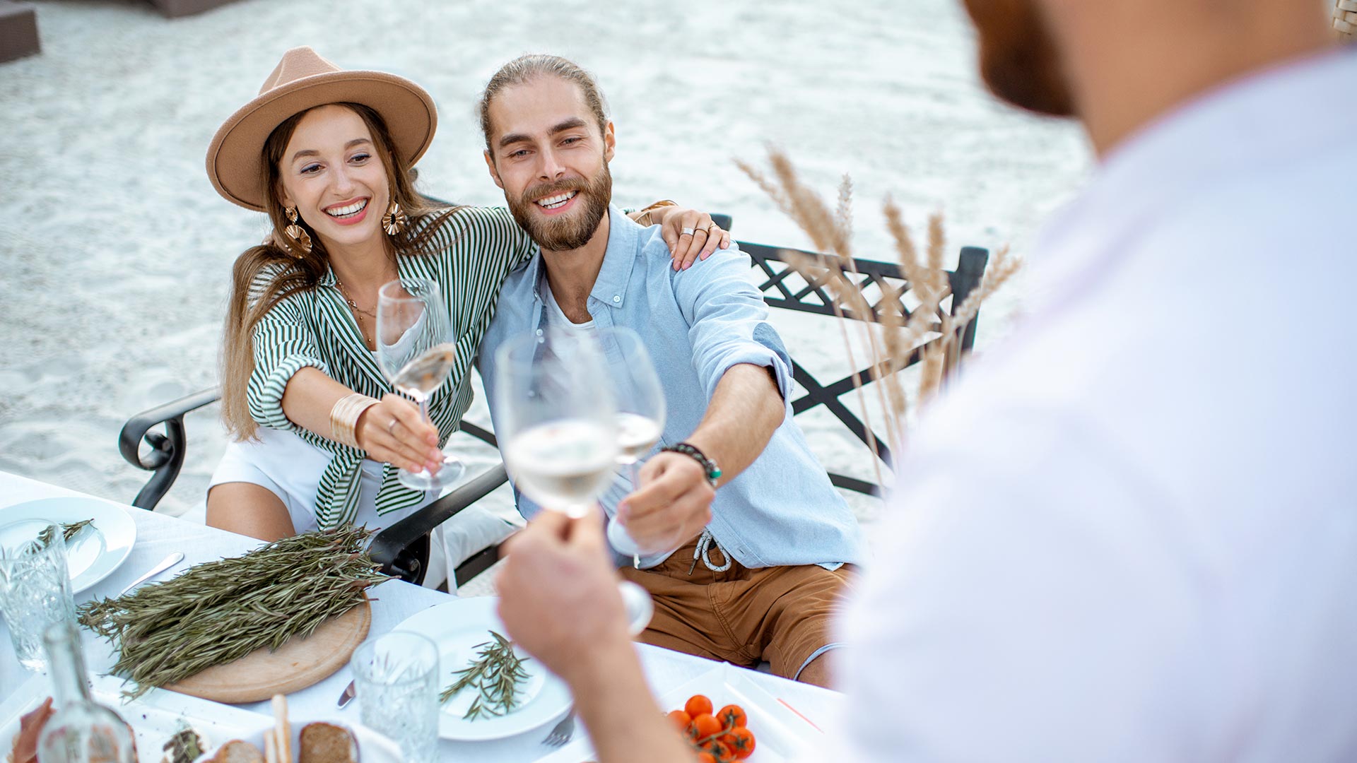 Amis portant un toast à une table près de la mer