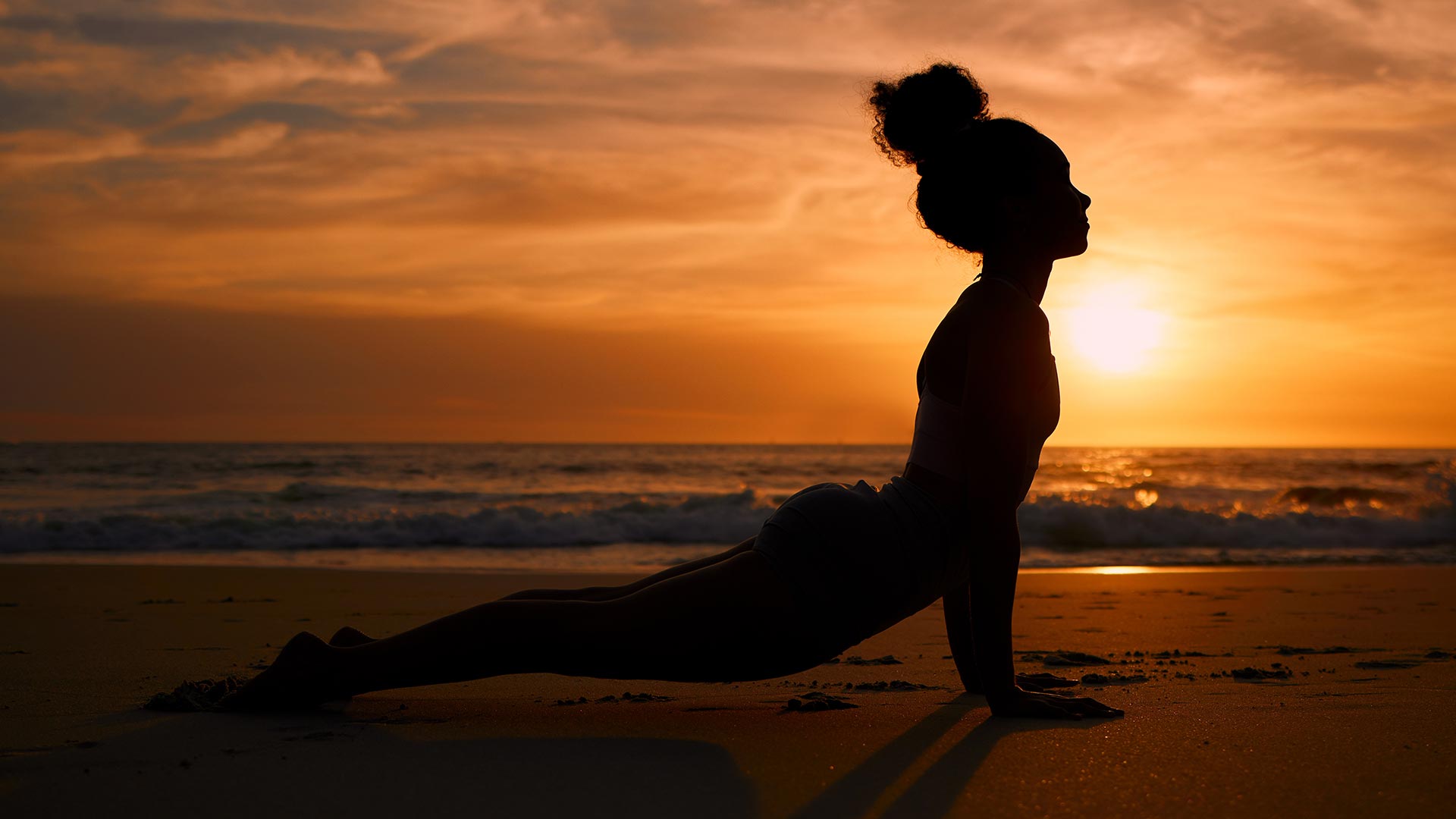 Yoga sur la plage au coucher du soleil